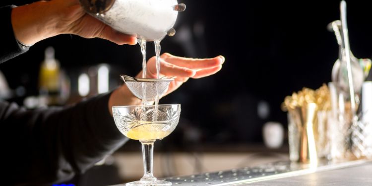 bartender pouring a drink at the bar