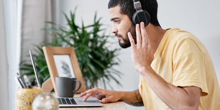 man writing captions with headphones