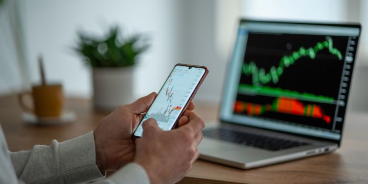 day trader sitting at a computer looking at stocks