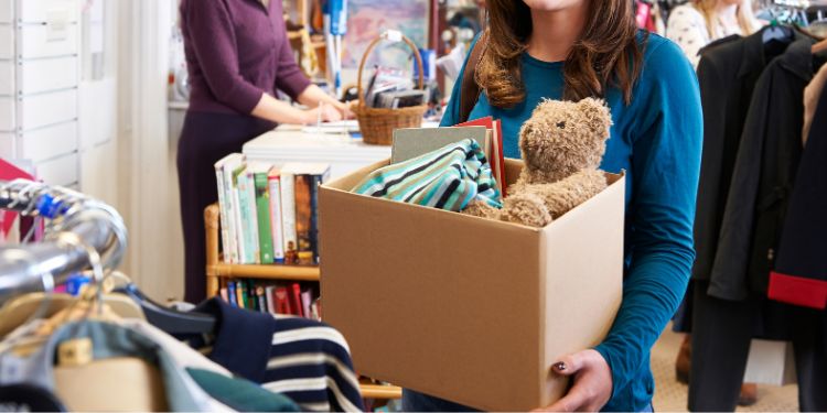 Woman carrying donation box full of books and other items