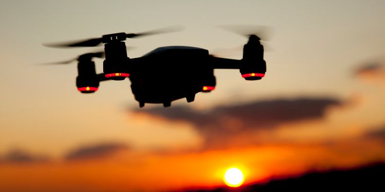 drone flying in the sky with a sunset