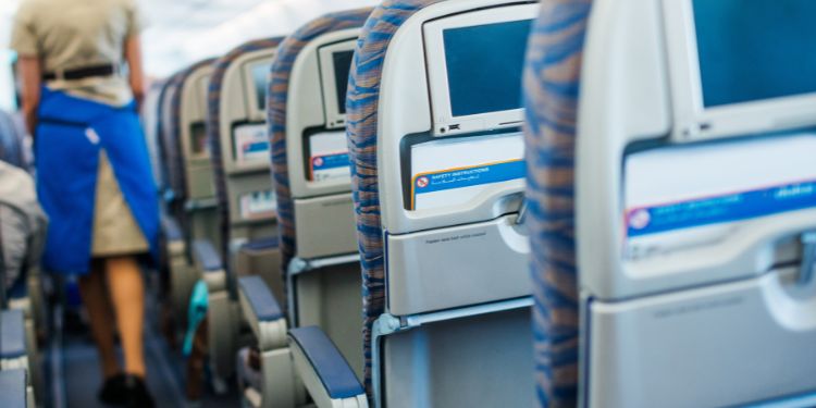 flight attendant walking through plane aisle