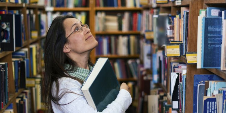 librarian looking at a bookshelf