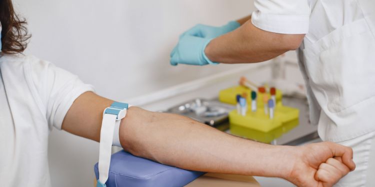 Phlebotomist drawing blood from patient