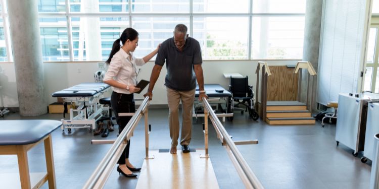 woman working as a physical therapist and helping a patient walk