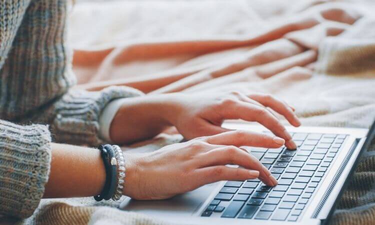 woman typing on computer as a virtual assistant