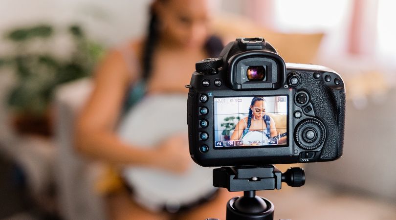 woman filming herself playing music with a camera