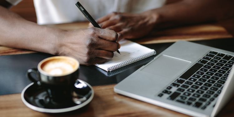 man taking notes at a coffee shop